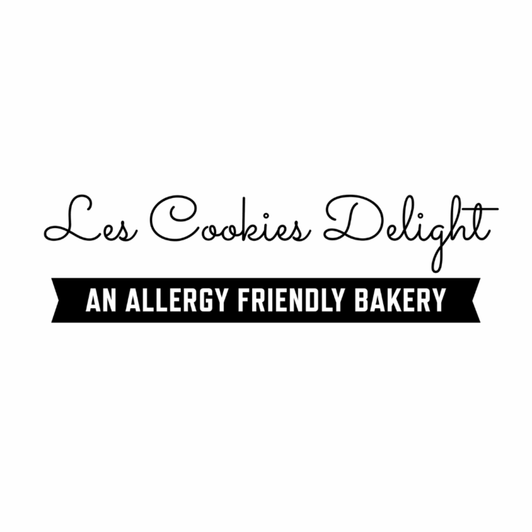 Text logo reads “Les Cookies Delight” in cursive above a black ribbon with bold white text saying “An Allergy Friendly Bakery.”.